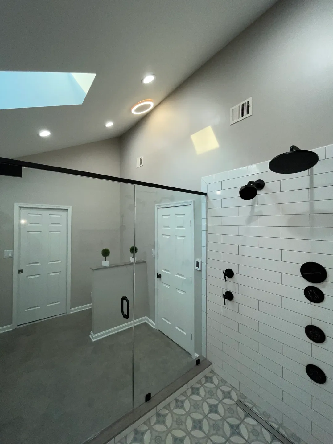 A bathroom with white walls and black accents.