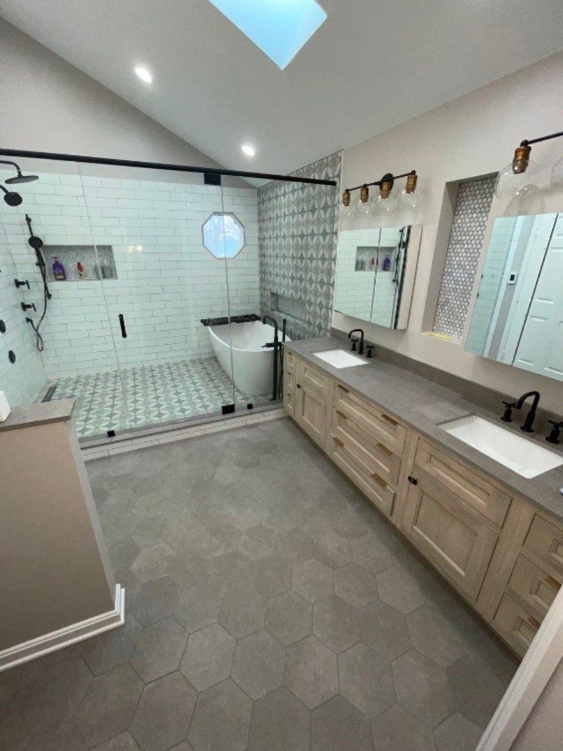 A bathroom with two sinks and a large shower.