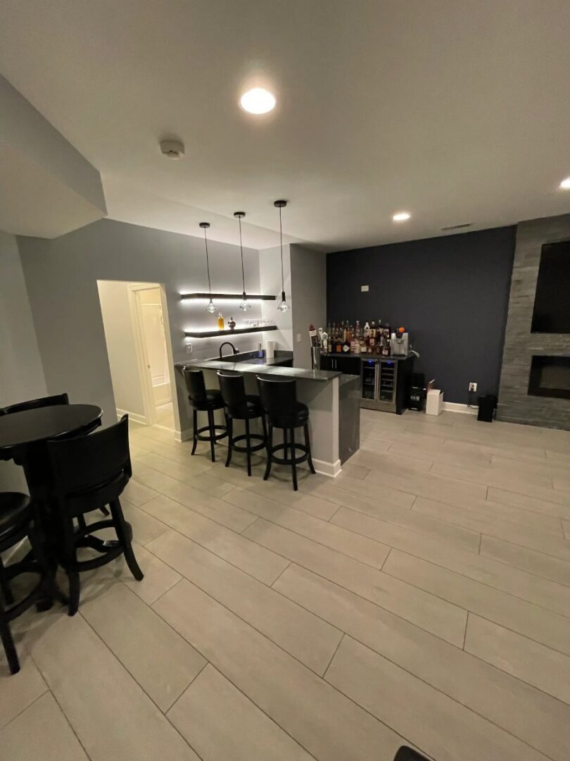 A kitchen with a bar and chairs in it