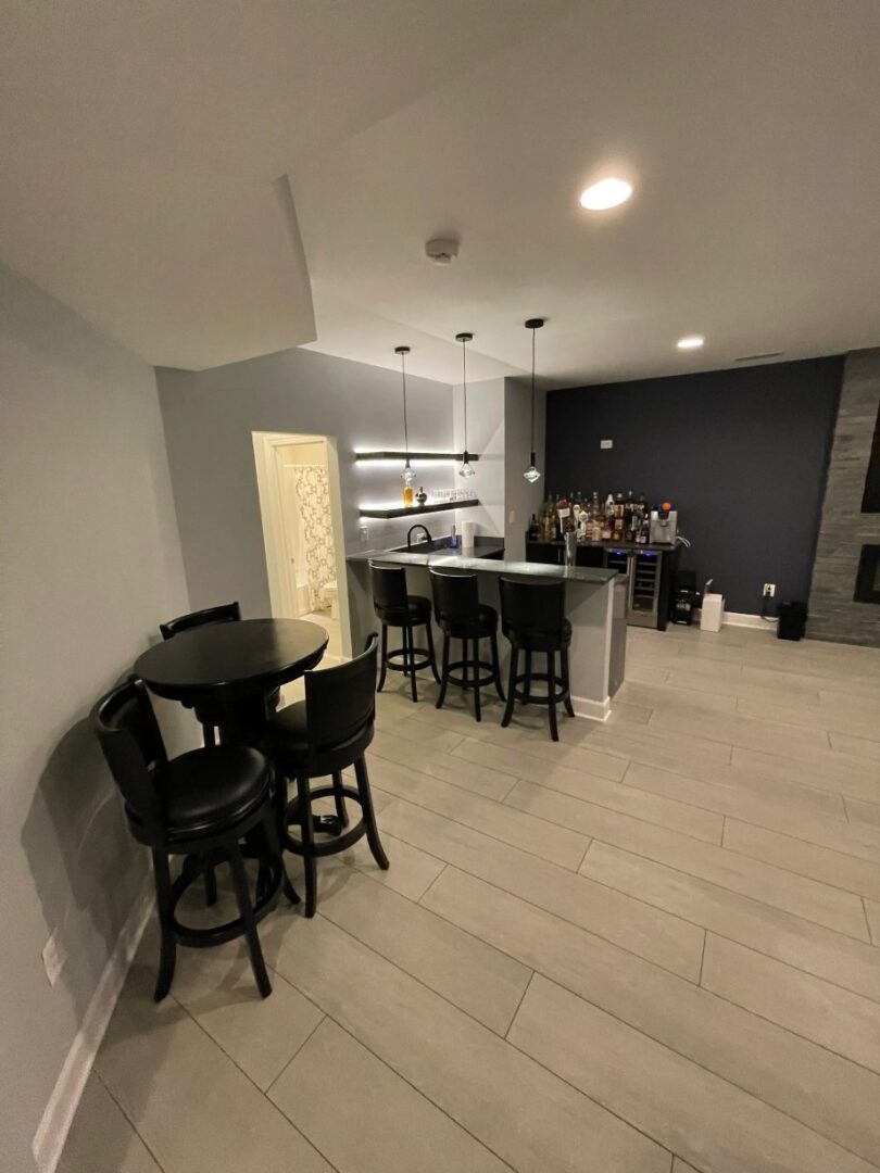 A room with a bar and chairs in it
