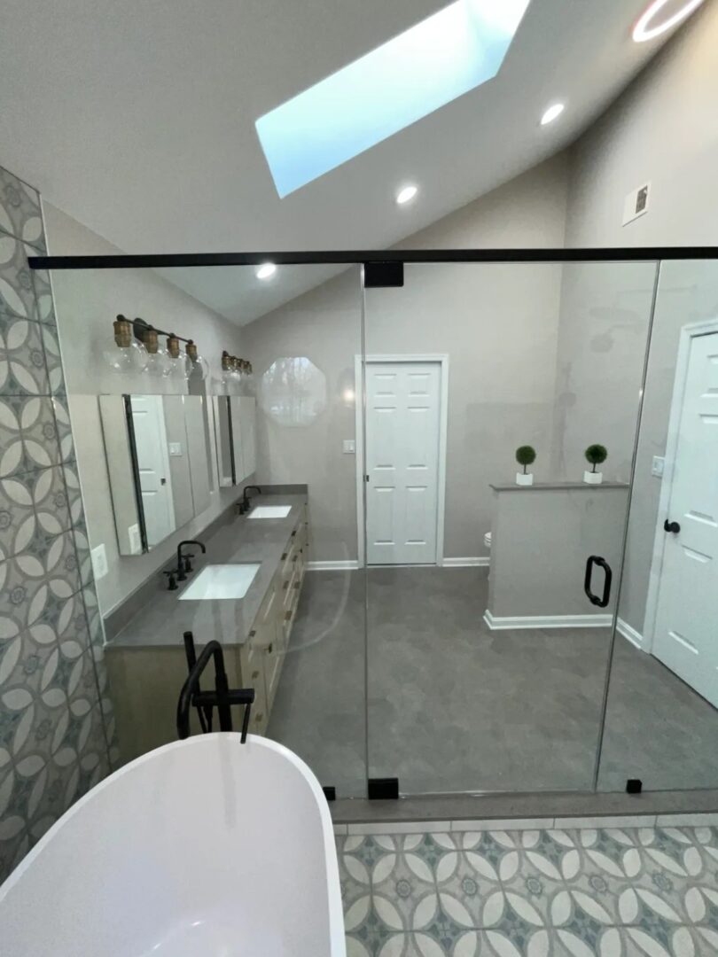 A bathroom with a large mirror and a white tub.