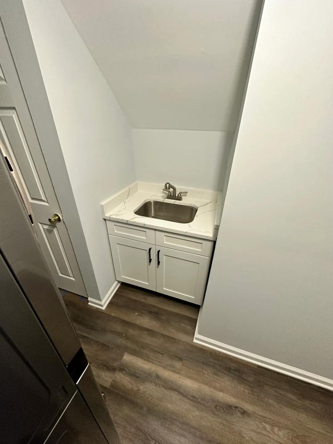 A sink and cabinet in the corner of a room.