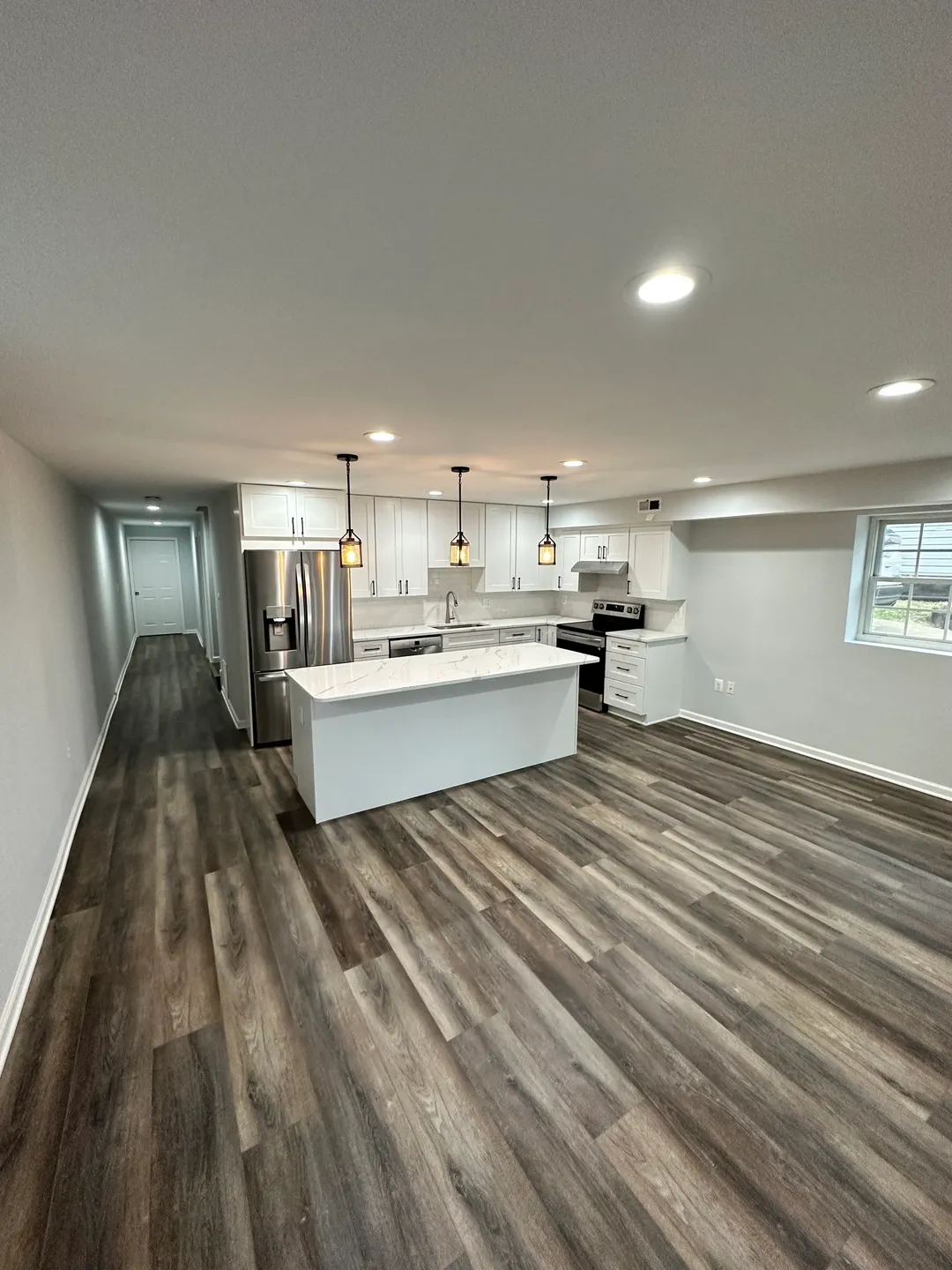 A kitchen with wood floors and white walls.