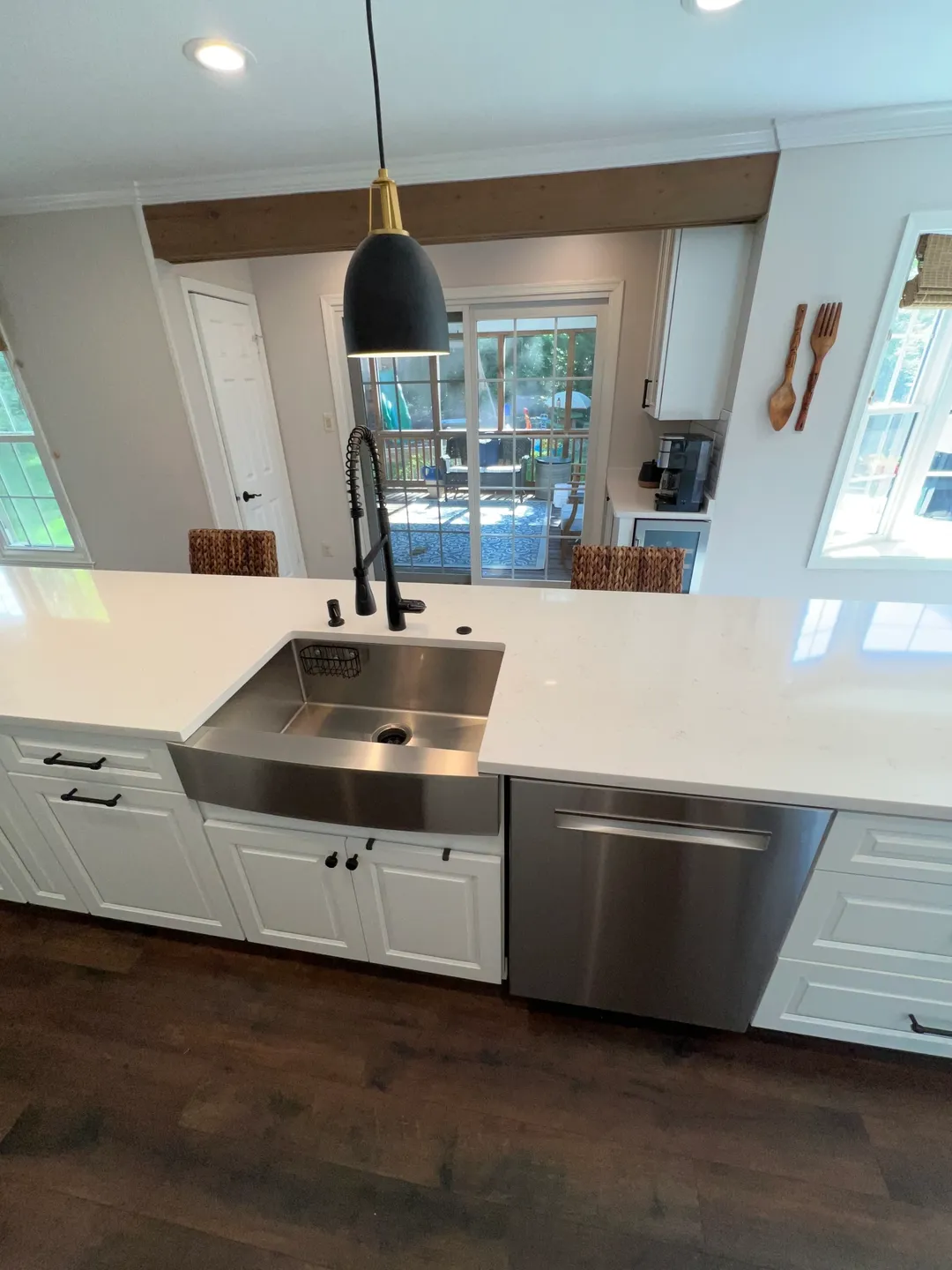 A kitchen with white counters and stainless steel sink.