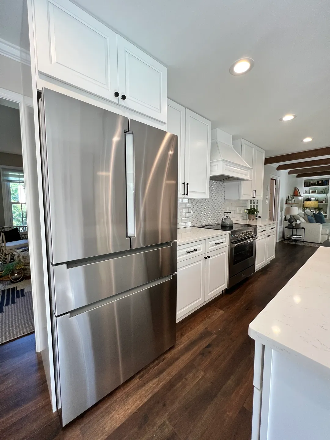 A kitchen with stainless steel appliances and white cabinets.