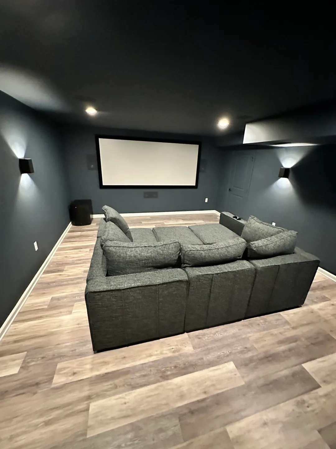 A room with a couch and a projector screen